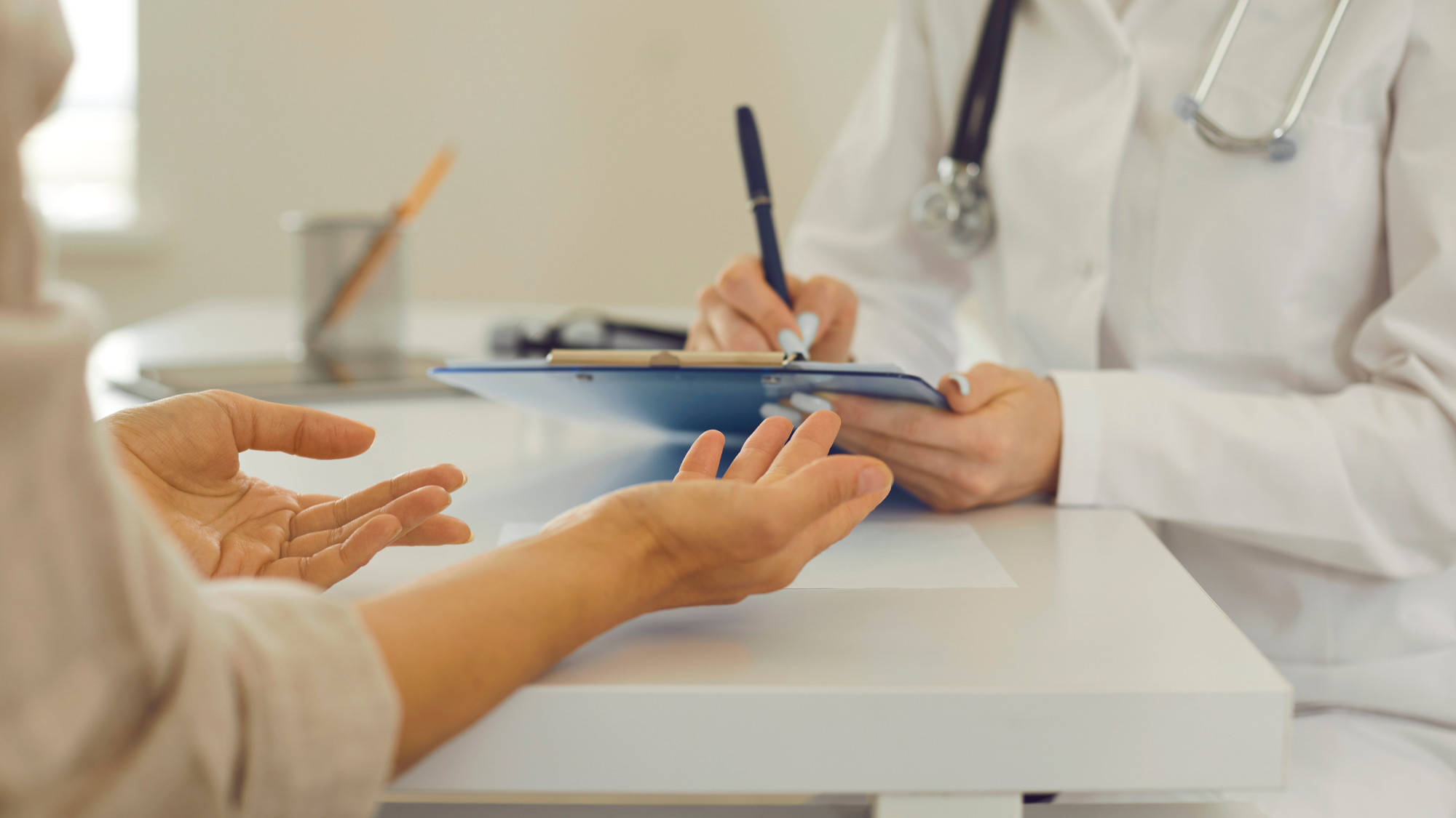 close up of hands of Doctor and patient with clipboard